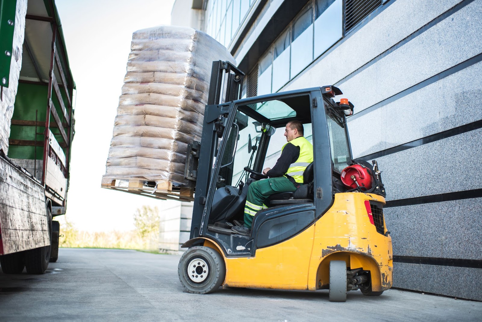 forklift operator using a forklift to load a pallet onto a truck